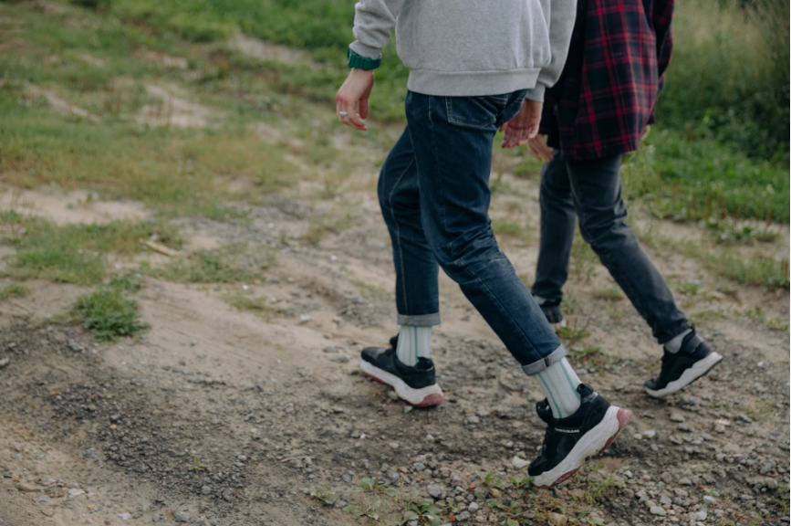 Two people walking along a dirt track